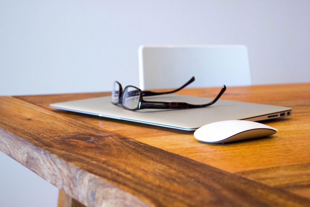 A pair of glasses rest on top a laptop | Spanish translation revision services